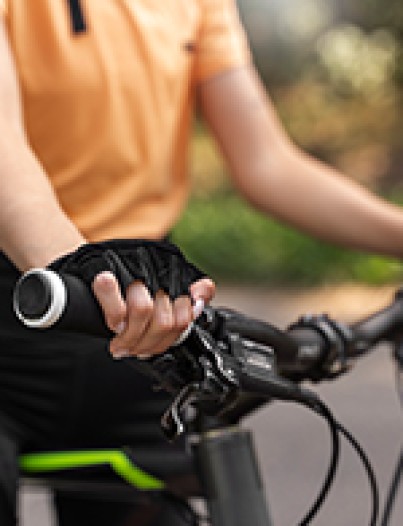 Image d'un guidon de vélo avec les mains d'une personne qui maintient le guidon.