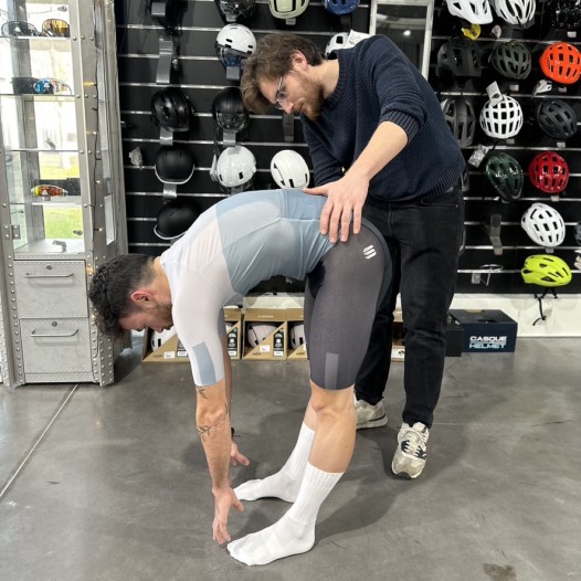 Image d'une personne qui fait des étirements avec une autre personne qui le maintient.